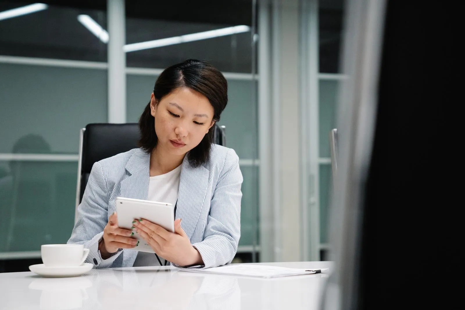 Professional reviewing work on a tablet at an office desk